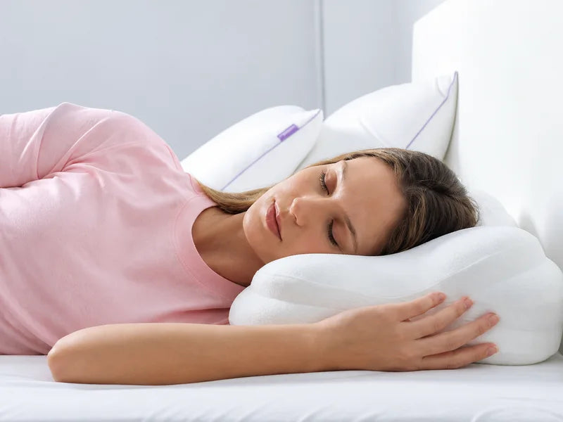 A woman resting her cheek on a contoured pillow.