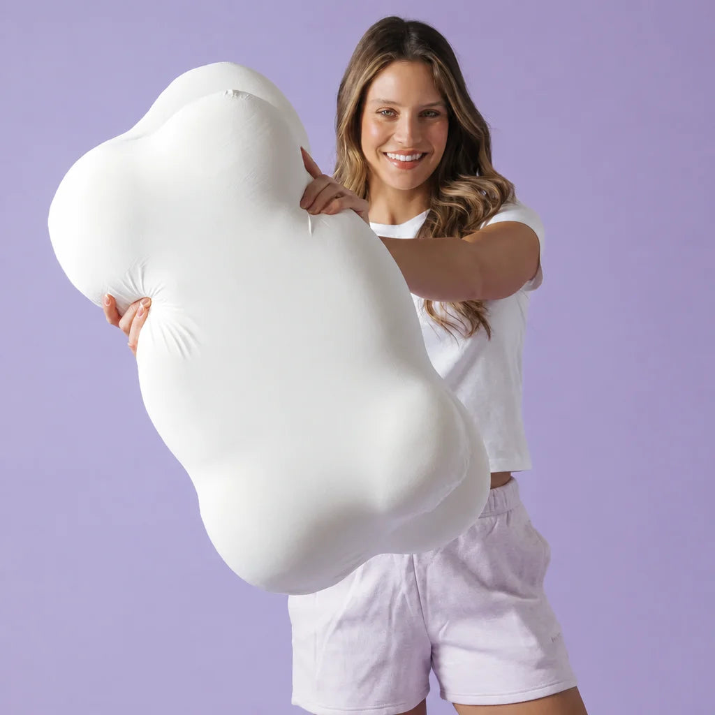 Woman holding the contoured pillow, showing its recessed centre and curved edges